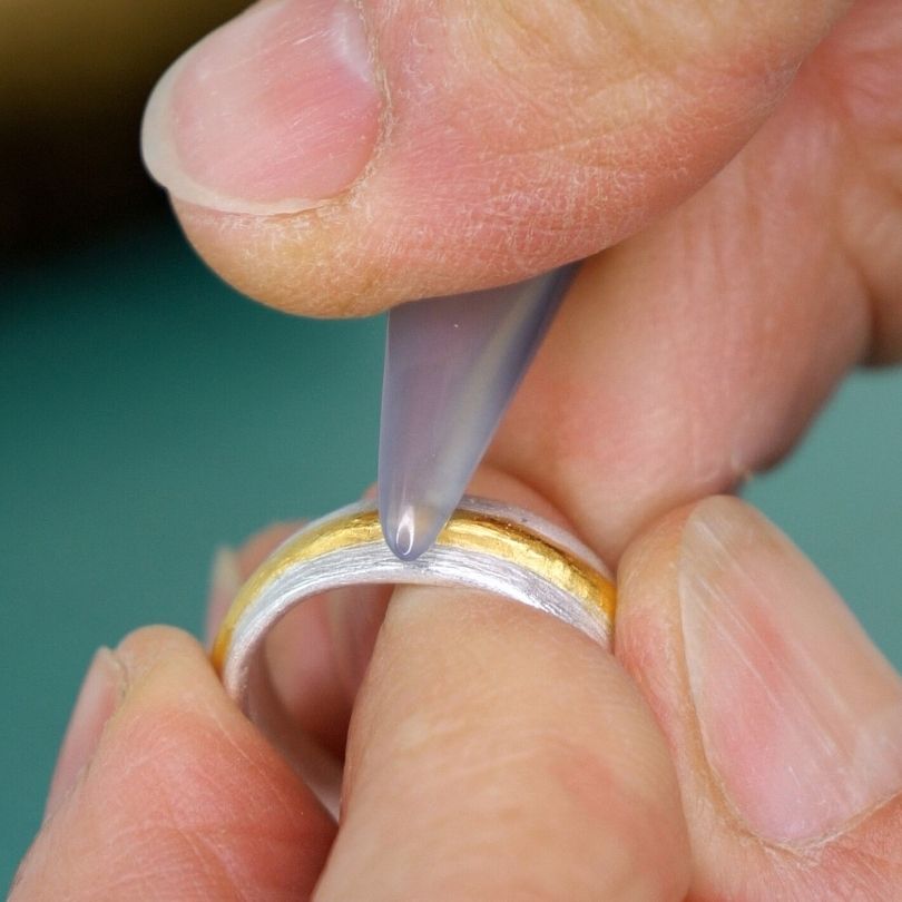 24K vergoldeten Silberring mit Achatpolierer polieren